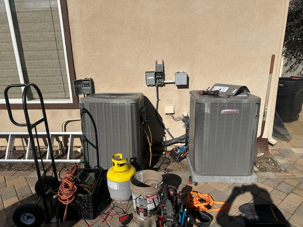 HVAC units with tools and equipment outside a home, ready for maintenance and repair.