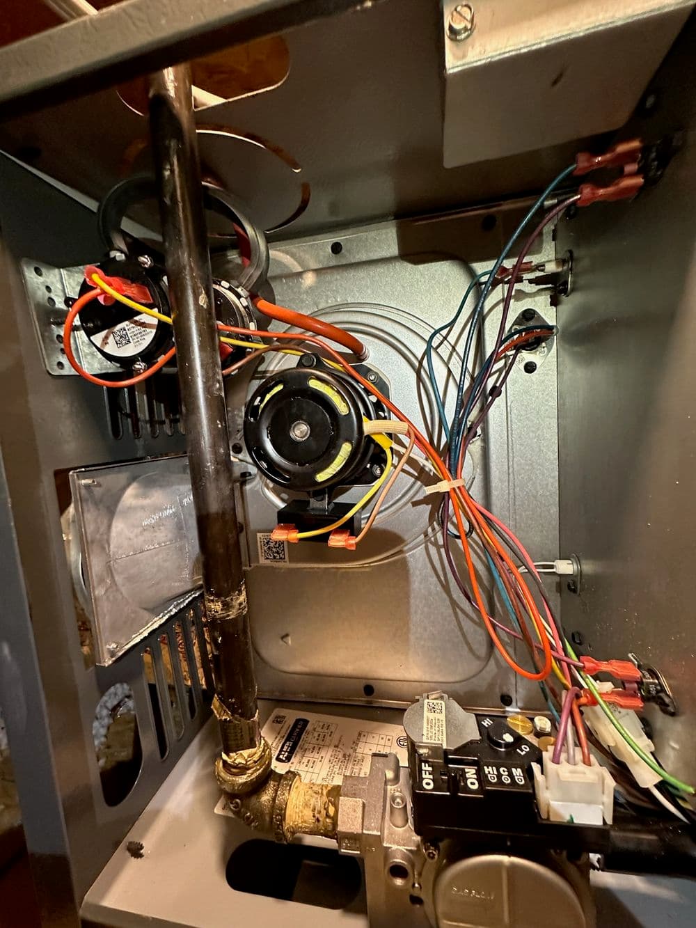Internal view of a furnace showing wiring and components for heating system maintenance.