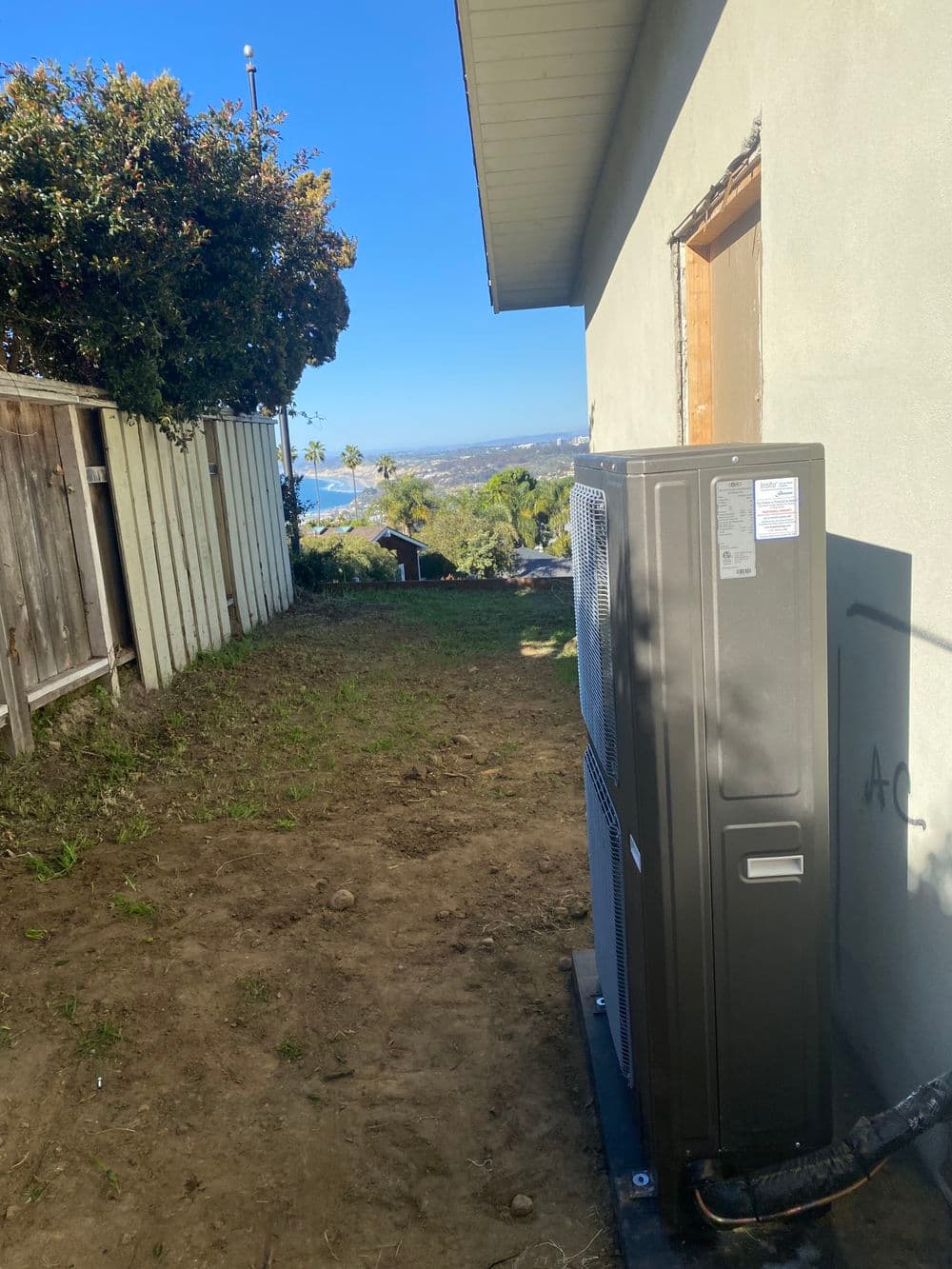 Heat pump installation beside a house with a view in a residential area.