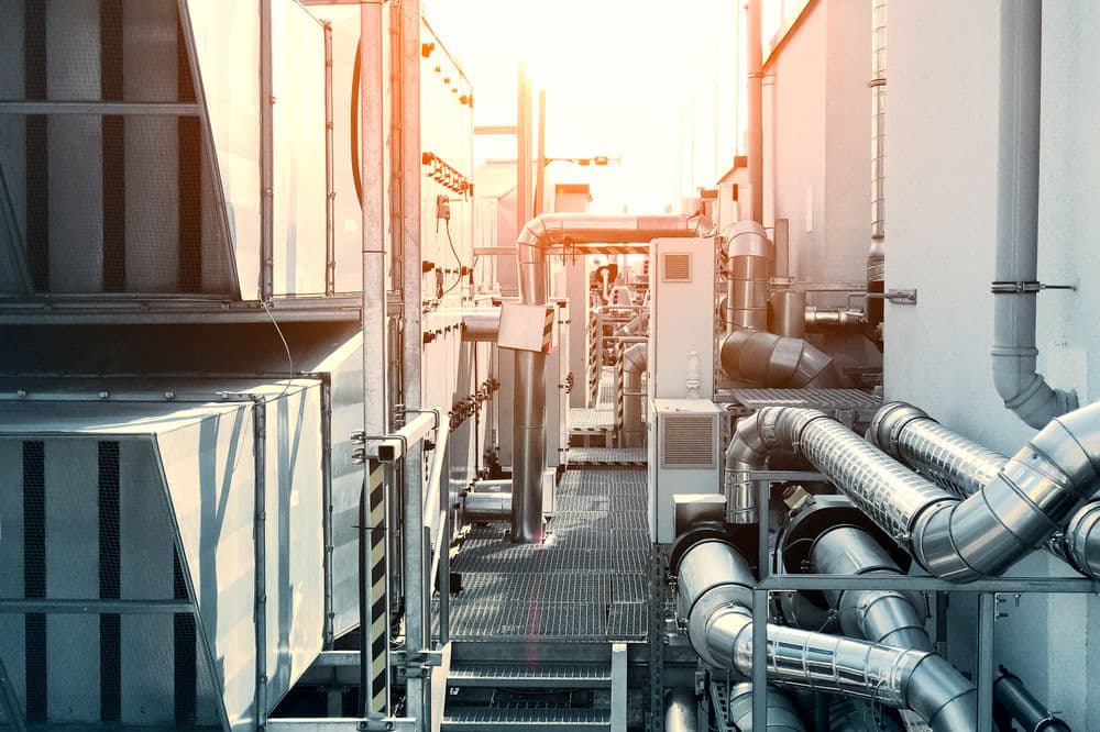 Industrial HVAC systems with piping and equipment under sunset lighting.
